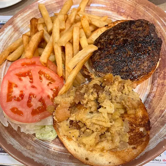 Charbroiled burger with French fries, lettuce, tomato and grilled onions