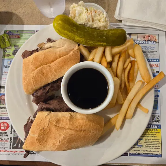 Roast beef sandwich served with French fries and pickle
