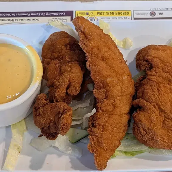 Crispy chicken tenders served with dipping sauce