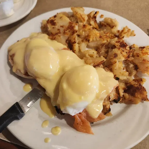 Eggs Benedict served with crispy hash browns